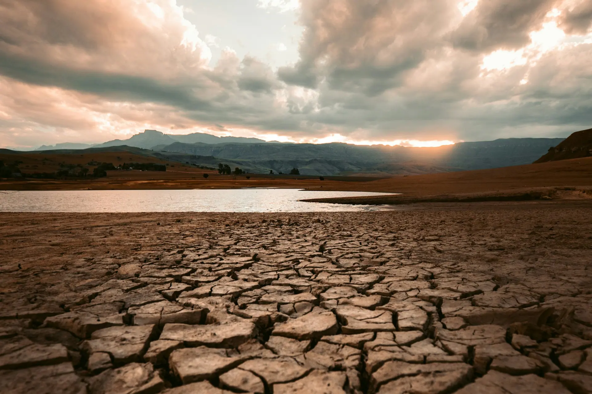 Cracked bed of a dried-out lake under a heavy sky