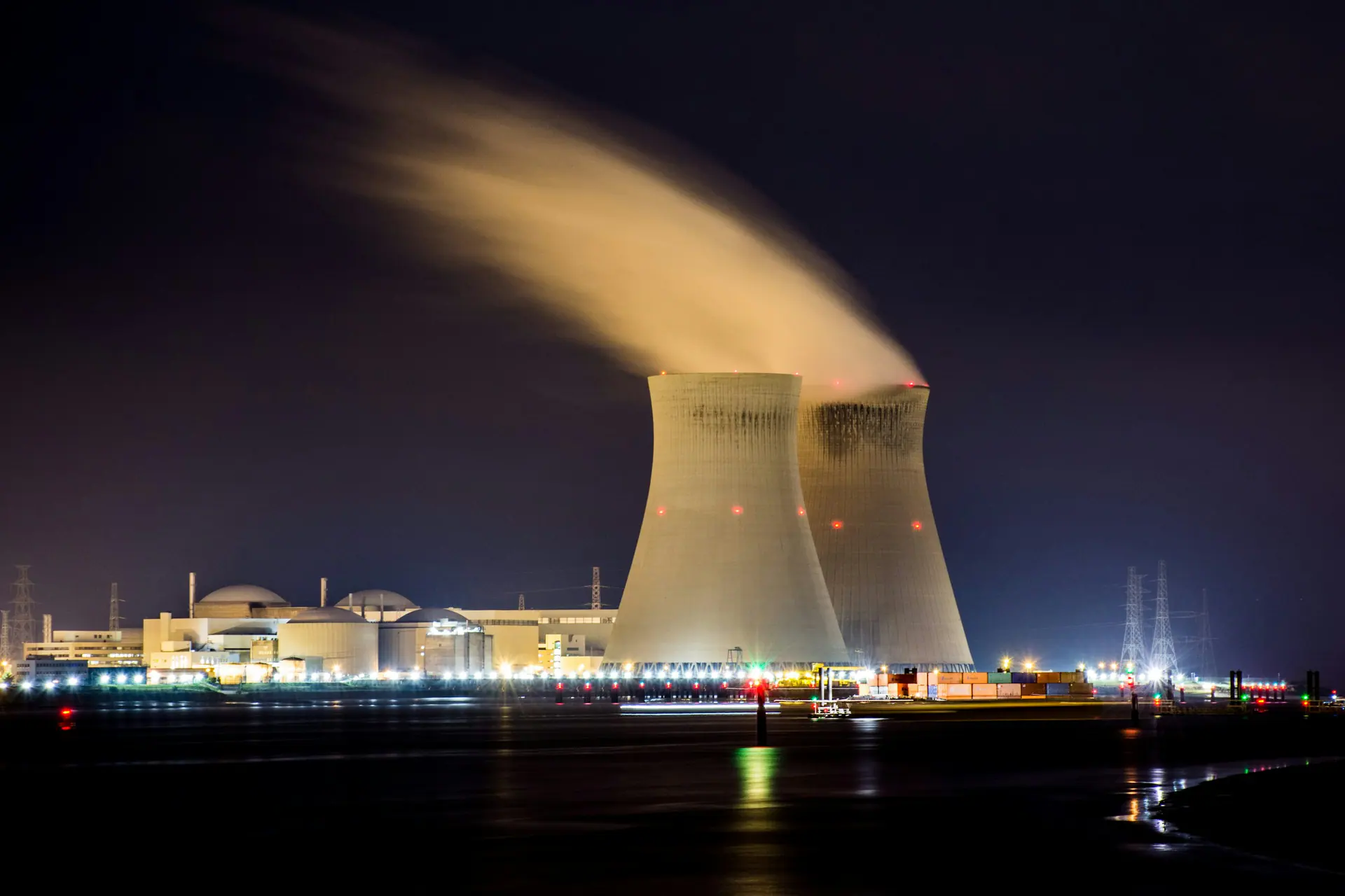 Cooling towers of a power station releasing steam through the night